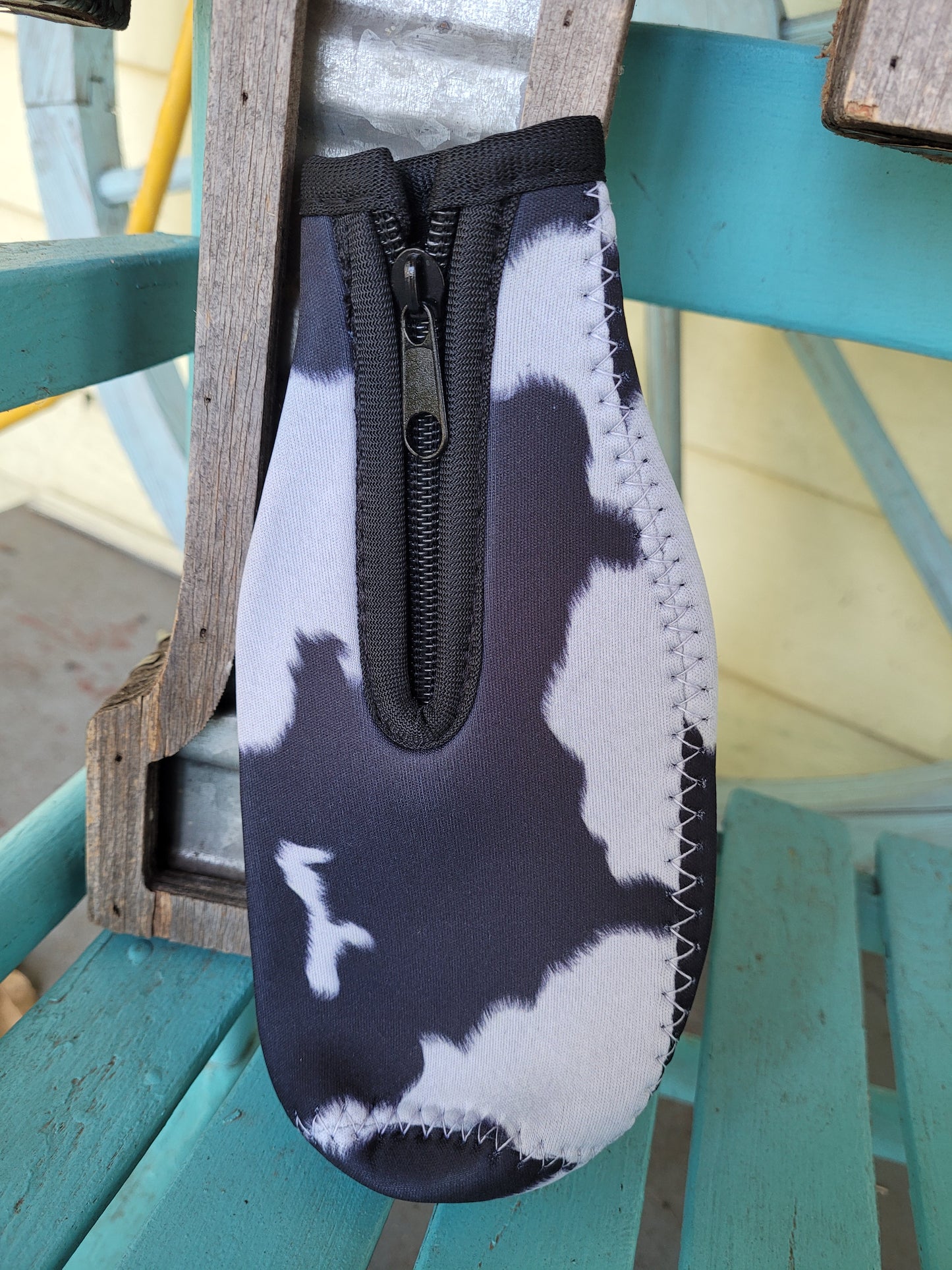 Black and white cow bottle koozie